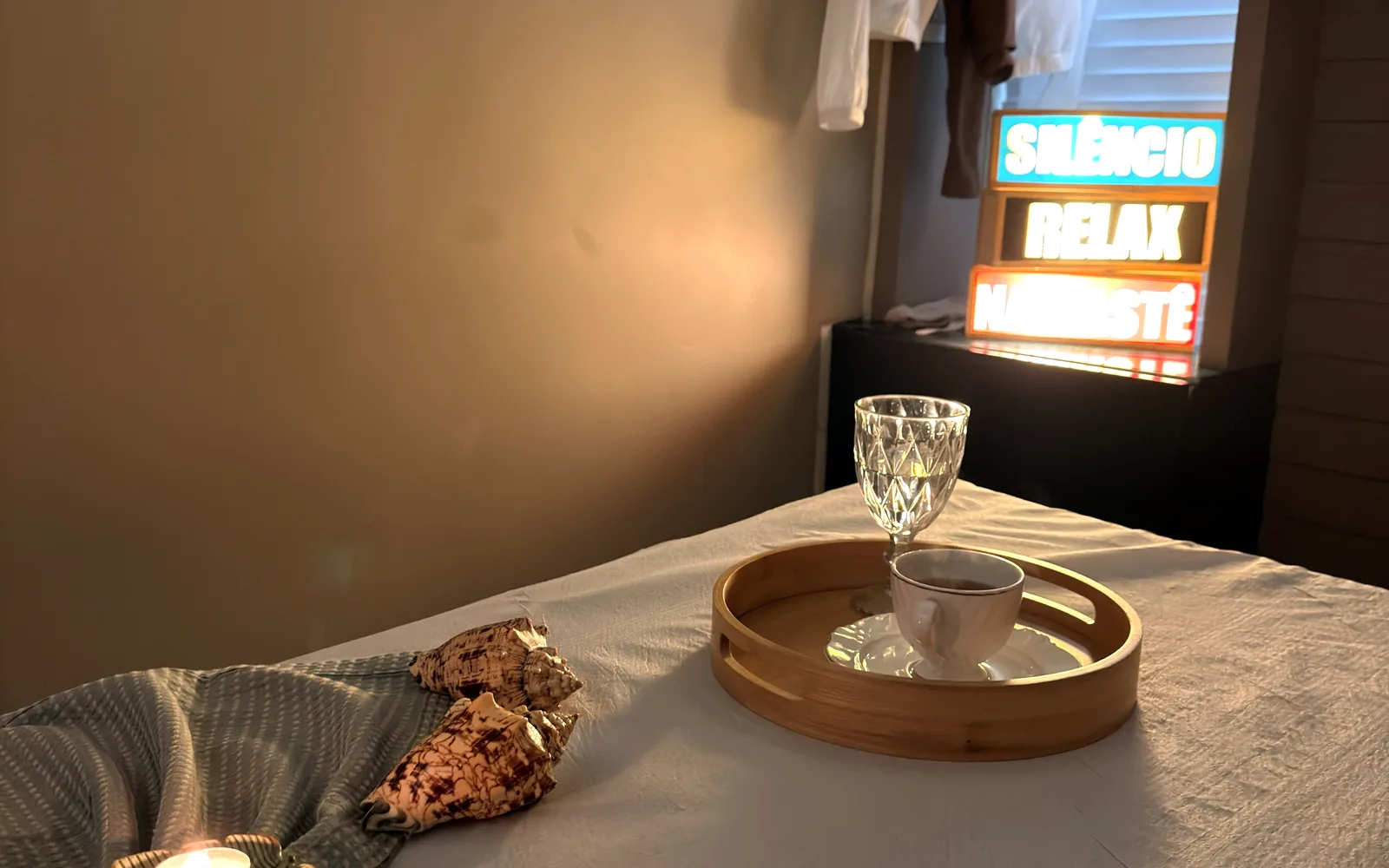 Sala de relaxamento do Sea Spa com maca preparada, velas e luz âmbar, ambiente aconchegante no Mucuripe, em Fortaleza