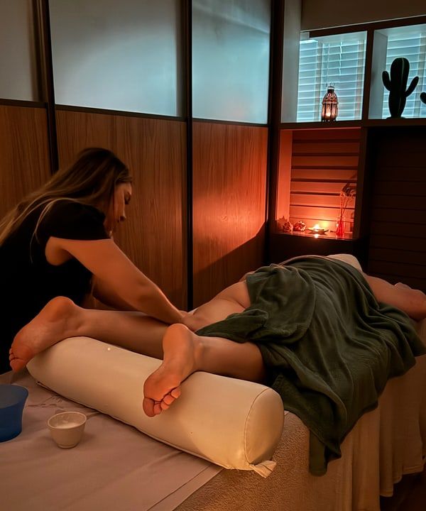 Massagem relaxante em andamento no Sea Spa, sala com luz âmbar, em Fortaleza